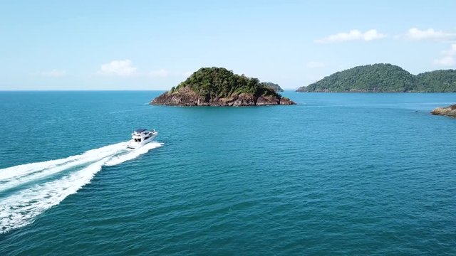 Aerial footage of speedboat cruising between islands, luxurious yacht charter