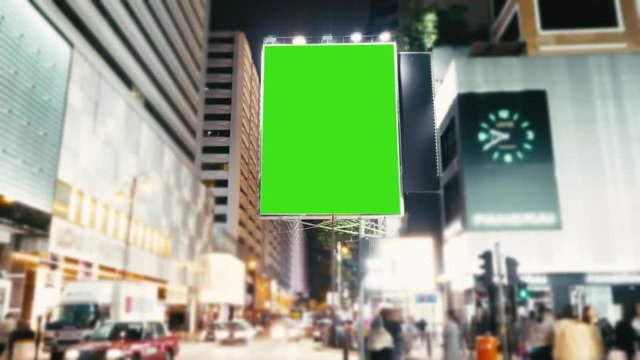 A Billboard with a Green Screen on a Evening Streets of Hong Kong .Time Lapse 