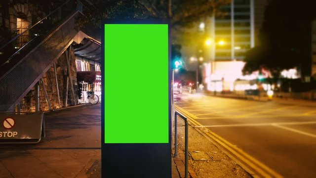 A Billboard with a Green Screen on a Evening Streets of Hong Kong .Time Lapse 