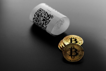 Bitcoin golden coins and paper receipt isolated on a black background