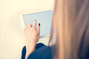 Girl on a tablet computer, browses the information. The white background and the screen