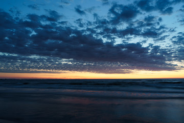 Naklejka na ściany i meble sunset over sea seen from the beach