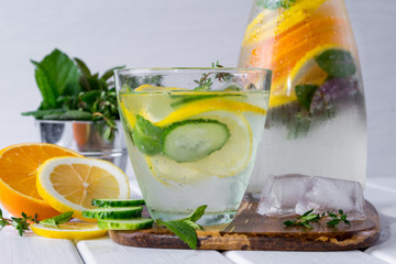 Mineral water with a lemon slices  and mint  on white wooden background