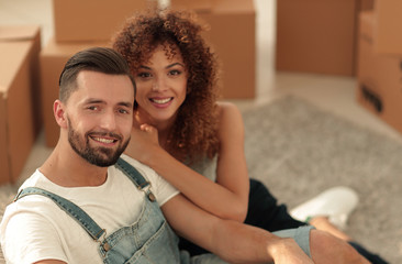 Young couple sitting on the floor in a new apartment