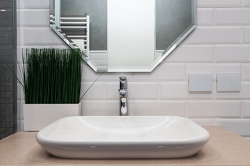 Bathroom interior. Bright bathroom with new tiles. New washbasin, white sink and large mirror