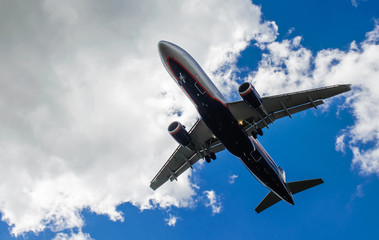 The plane on a background of blue sky and white clouds.