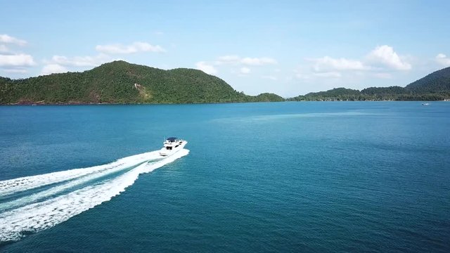 Luxury motor yacht cruising in blue bay water, drone aerial footage