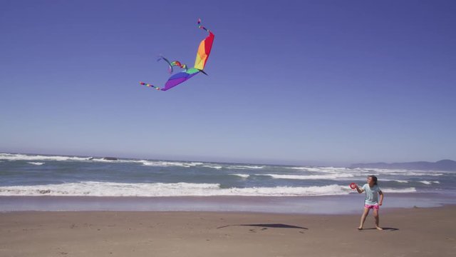 Young girl flying kite at beach