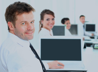 Fototapeta premium Portrait of a happy man entrepreneur displaying computer laptop in office.