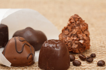 Chocolate candies various shape, coffee beans and white paper pack