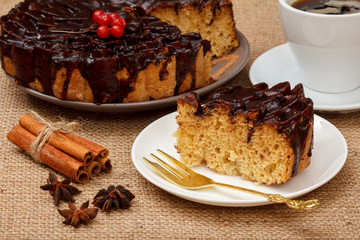 Chocolate cake decorated with bunch of viburnum, cup of coffee, star anise and cinnamon