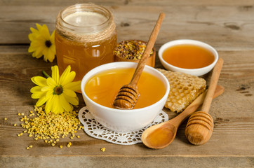 bee products (honey, pollen,honeycombs) on wooden background