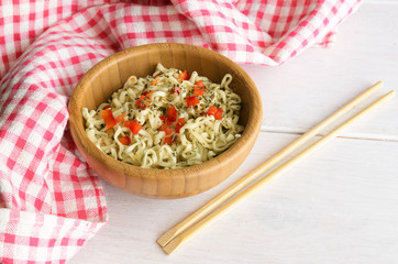 Instant noodles  in bowl and wooden chopsticks on  table with copy space. Traditional Asian  food.