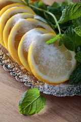 Lemon slices with sugar and mint leaves.