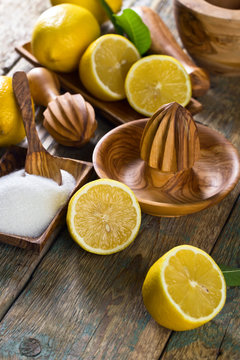 Lemons , sugar and old wooden squeezer .