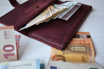 Euro money banknotes and wallet on the white wooden desk. Business money background.