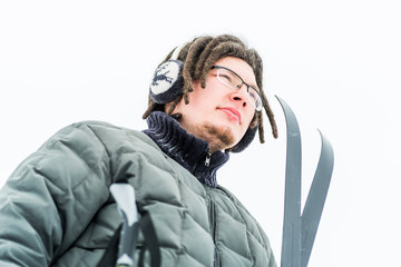 young caucasian man with afro hairstyle holding ski equipment outdoors