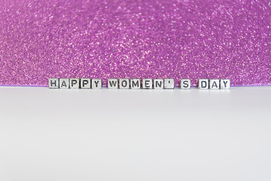Background for woman's day on 8 March with letter put on white floor and background violet or purple gilter