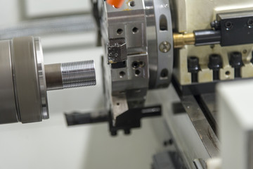 The CNC lathe machine cutting the thread at the end of the pipe.The water pipe manufacturing process.