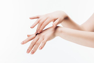 cropped shot of woman applying moisturizing cream on hands isolated on white
