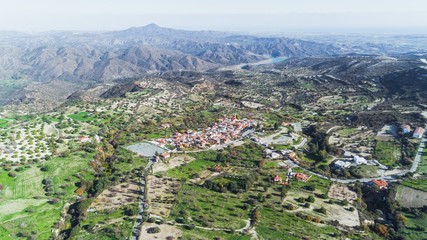 Aerial bird eye view of famous landmark tourist destination valley Kato Lefkara village, Larnaca, Cyprus. Ceramic tiled house roofs, at south of Troodos hills, Kionia and river Sirkatis from above.