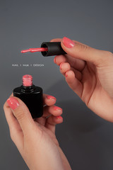 
Female beautiful hands to hold a bottle of lacquer. Gel-lacquer. Women's business. Beautiful manicure of female hands