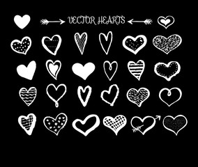 Collection of hand sketched doodle hearts isolated on black background.