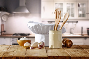 cook hat on wooden table and kitchen interior 