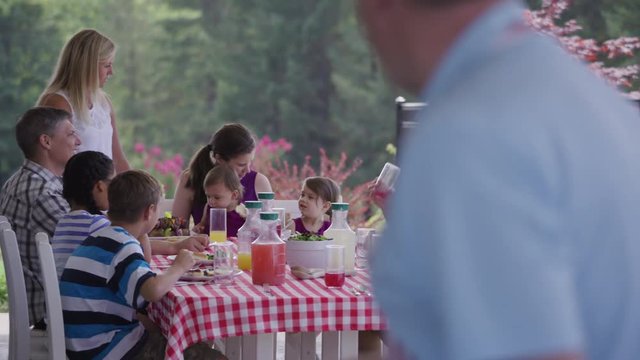 Group of people eating and enjoying a backyard barbeque