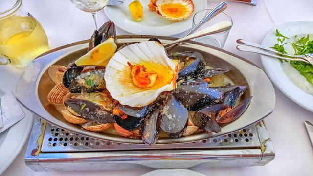 Great dish with the delicious oysters and scallops on ice with lime is served with champagne and herbs. Serving.