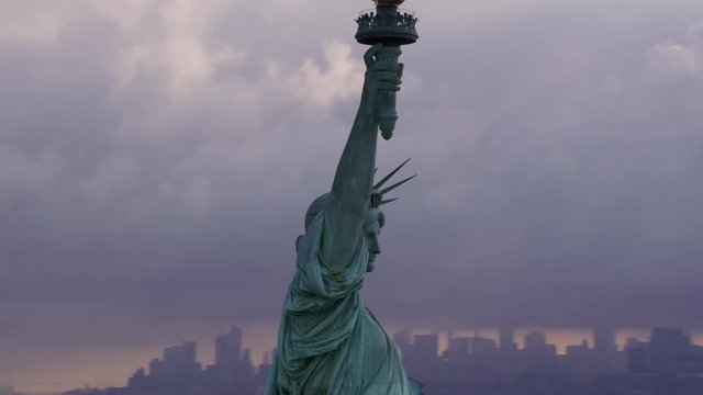 New York City circa-2017, Pull out from close-up of Statue of Liberty to reveal Manhattan and morning clouds.  Shot with Cineflex and RED Epic-W Helium. 