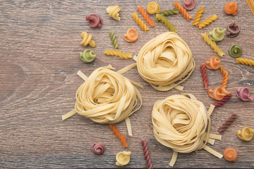 Mixed dried pasta selection on wooden background. Top view with copyspace for your text