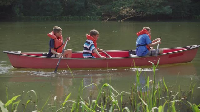 Kids at summer camp paddling a canoe
