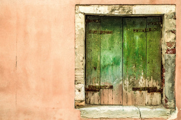 square  weathered closed window in Venice, Italy.