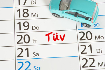 Ein Auto und ein Kalender mit dem Termin für eine technische Hauptuntersuchung Tür