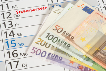 Ein Kalender mit dem Termin beim Steuerberater und Euro Geldscheine