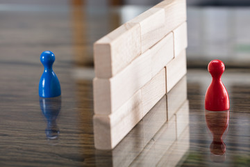 Red And Blue Figurine Paw Separated By Wooden Blocks - obrazy, fototapety, plakaty