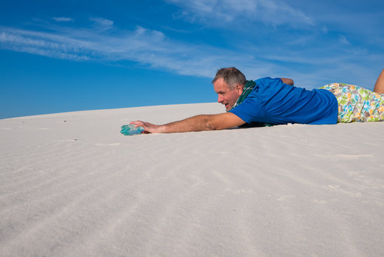 Exhausted man is crawling on the sand