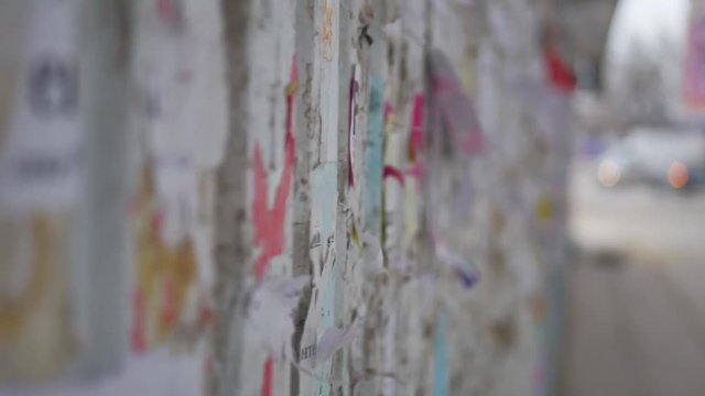 Colorful torn posters on grunge old walls as creative and abstract background