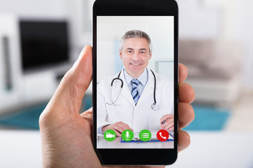Obraz premium Person Video Conferencing With Doctor On Smartphone