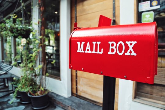 Red mail box in front of a house Concept of e commerce Nowadays Post office mainly provide shipping service