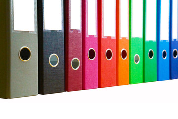 Colorful lever arch file folders in one line. Thick document cases of different colors with white fields for text and iron rings in the cover. Office stationery isolated on white background