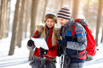 Hikers couple looking for path on map