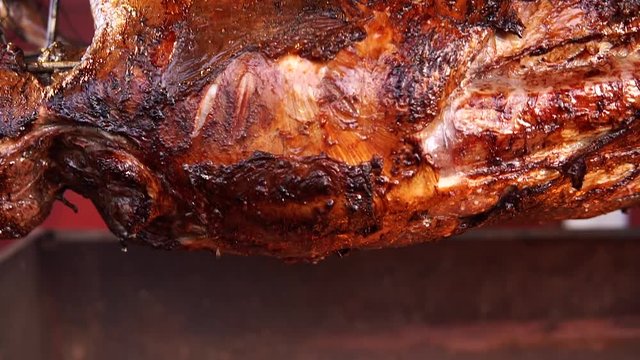 Big, juicy, whole lamb roast on a spit at the autumn fair.