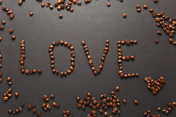 Top view of letter love, word made from coffee beans on black background for design. Saint Valentine's Day card on fabruary 14, holiday concept. Copy space for advertisement.