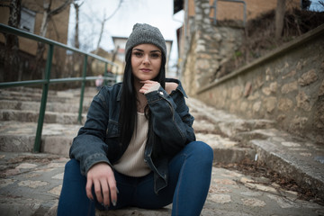 beautiful black hair woman with knitted hat on head sitting on steps 