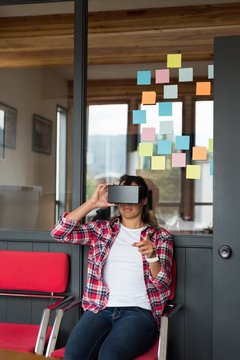Female executive sitting on chair and using virtual reality