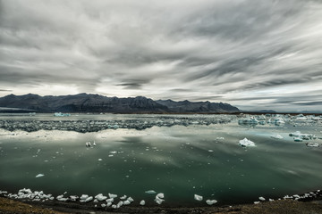 Obraz premium View of the glacier and the lake with ice. Beautiful northern landscape. Iceland. Dramatic, severe appearance. 