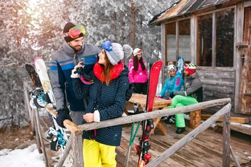 Crédence de cuisine en verre imprimé Sports dhiver couple with friends spending holiday in winter snow cottage