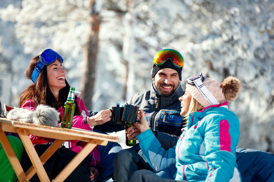 winter holidays – Smiling friends drinking beer on break at ski resort